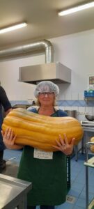 A giant pumpkin in the hands of a Community Kitchen volunteer